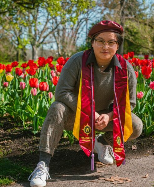 Dio strikes a graduation pose next to a tulip field